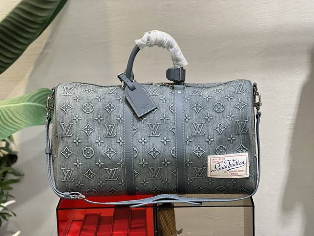 M22532 本款 Keepall Bandouli re 50 旅行袋为褪色丹宁布压印 Monogram 图案 重塑路易威登的经典设计之一 加固侧带和顶部手柄