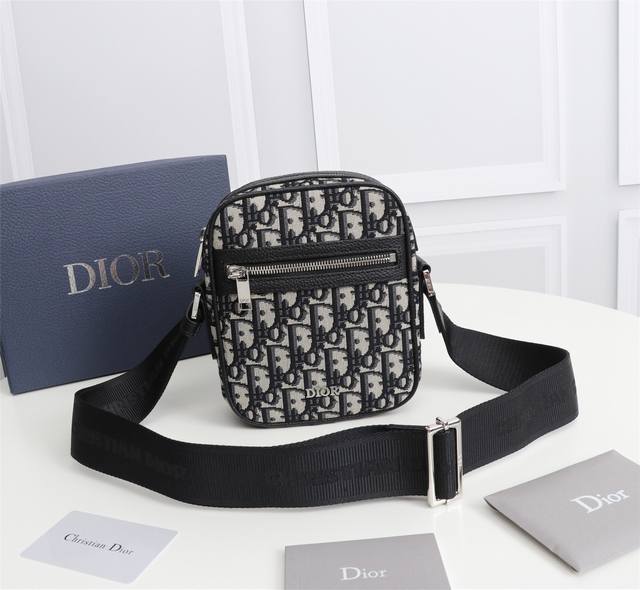 Dior 这款信使包是本季新品 精巧实用 是日常的理想良伴 采用米色和黑色 Oblique 印花面料精心制作 饰以黑色粒面牛皮革细节 拉链隔层和正面口袋可收纳各