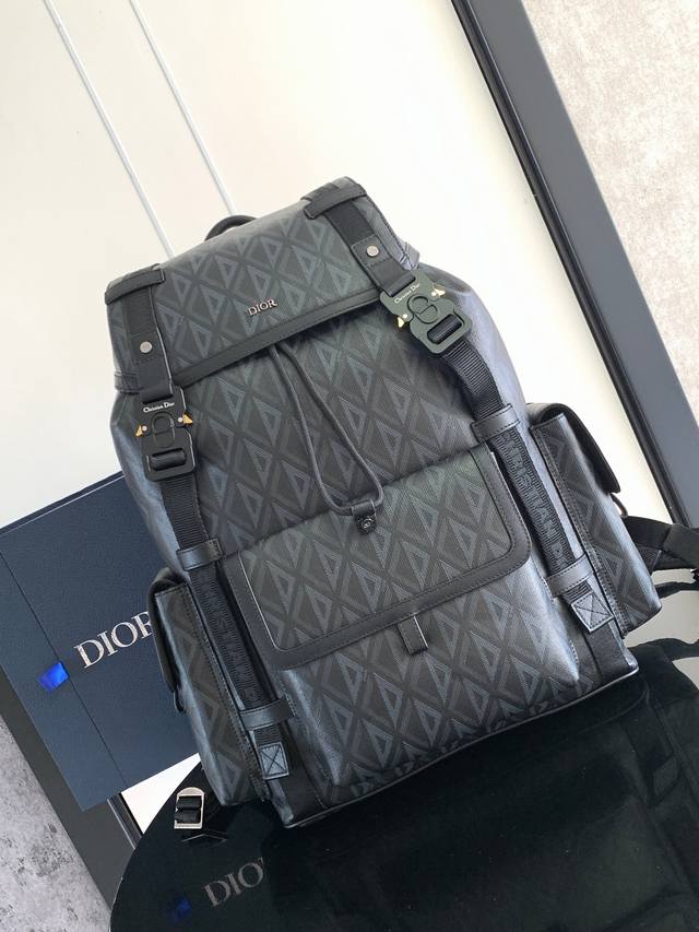 这款 Dior Hit The Road 双肩背包是本季的全新款式，将现代风格与 Dio 的高订精神融为一体。采用迪奥黑 Cd Diamond 图案帆布精心制作