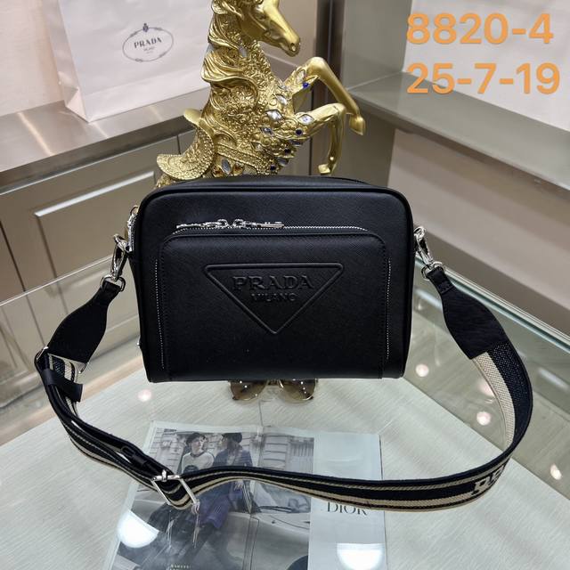 Prada 普拉达8820-4 这款时尚简约的单肩包取材品牌标志性的saffiano皮革，呈现别致的交叉平行线阴影纹理和涂蜡饰面。Prada富有象征意义的三角形