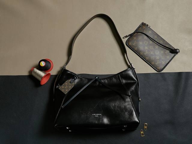 爆款 M25143 Carryall Dark 中号手袋以柔软羊皮革塑造时尚慵懒廓形，为 2024 春夏秀场造型增添瞩目姿彩。抛光金属件与触感良好的微皱纹理互为