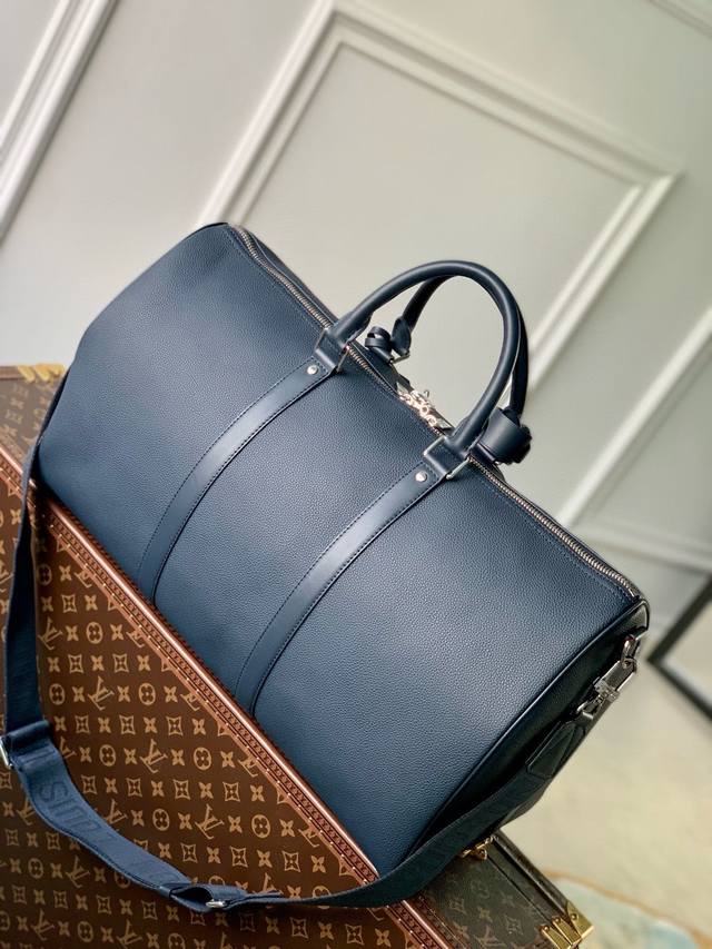 路易威登 M21420蓝色本款 Keepall 旅行袋选用 Lv Aerogram 牛皮革塑造经典构型，见证路易威登的精湛皮革匠艺。皮革标签和提花肩带援引品牌旅