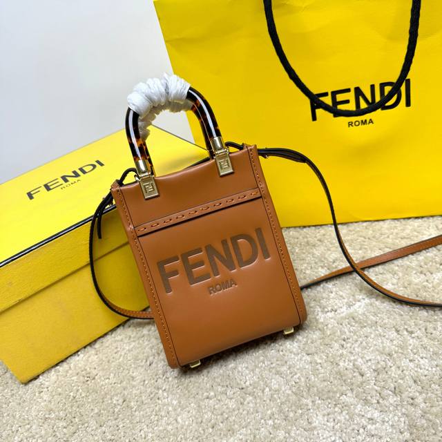 原单Sunshin棕色皮革迷你手提袋 饰有烫印Fendi Roma字样和玳瑁效果硬质有机玻璃提手 配备带衬里内部隔层 点缀同色系皮革饰边和金色金属件 采用两个提